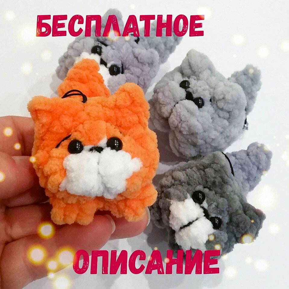 A crocheted gray plush cat with black stripes and a pink nose, sitting down